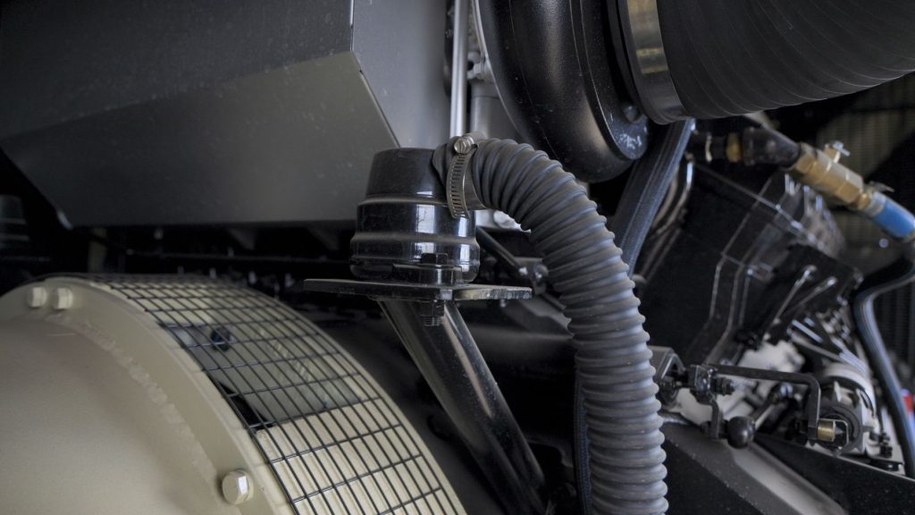 Generator crankcase breather being inspected for restriction Generator crankcase breather being inspected for restriction