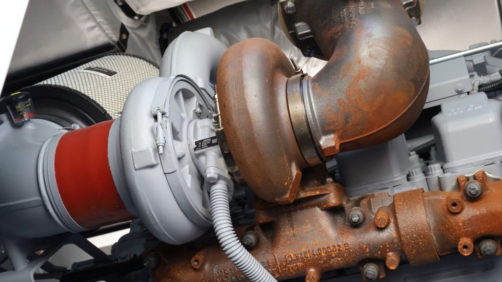 Technician inspecting turbocharger for shaft play and bearing wear