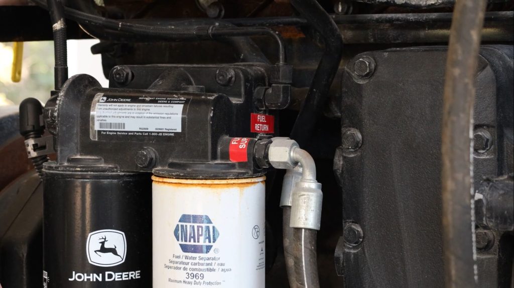 Technician draining water from fuel separator bowl Technician draining water from fuel separator bowl